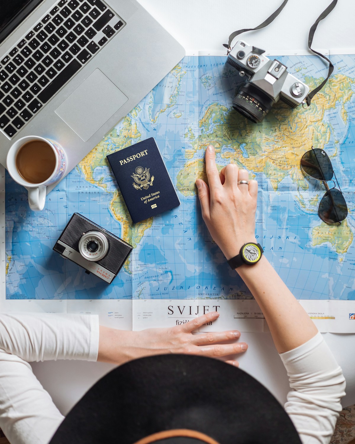 世界地図と旅行書類を並べて行き先を確認する様子